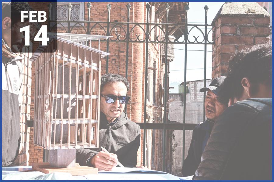 Image of people sitting around a table with building model. 